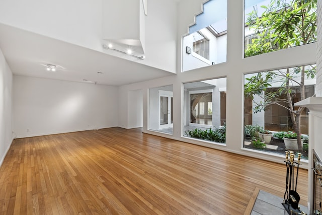 1016 Barkdull St, Houston, TX 77006 - unfurnished living room featuring light wood-type flooring, a fireplace, and a high ceiling