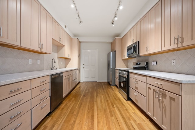 1016 Barkdull St, Houston, TX 77006 - kitchen with appliances with stainless steel finishes, light brown cabinets, light wood finished floors, tasteful backsplash, and light stone countertops