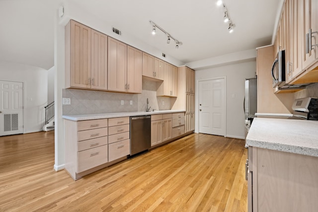 1016 Barkdull St, Houston, TX 77006 - kitchen featuring stainless steel appliances, light wood-style flooring, and light brown cabinets