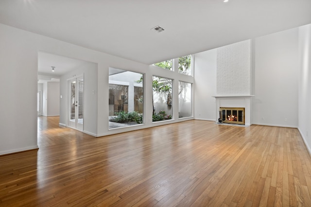 1016 Barkdull St, Houston, TX 77006 - unfurnished living room featuring light wood-type flooring and a brick fireplace