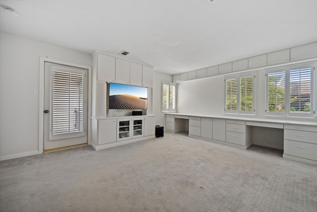 1016 Barkdull St, Houston, TX 77006 - unfurnished living room featuring built in desk and light colored carpet