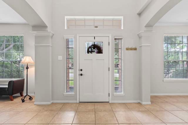 12727 Regal Pine Ln, Houston, TX 77070 - foyer featuring light tile patterned floors, plenty of natural light, ornate columns, and crown molding