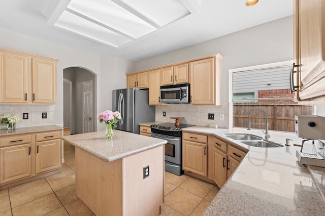 12727 Regal Pine Ln, Houston, TX 77070 - kitchen with appliances with stainless steel finishes, light brown cabinetry, backsplash, arched walkways, and light stone countertops