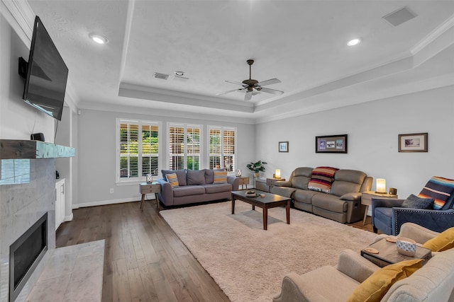 5523 Darschelle Dr, Houston, TX 77069 - living area featuring a tray ceiling, a ceiling fan, dark wood finished floors, a fireplace, and ornamental molding