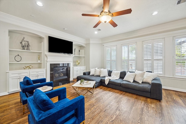 918 Detering St, Houston, TX 77007 - living area featuring a fireplace with flush hearth, ceiling fan, ornamental molding, built in features, and wood finished floors