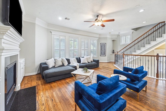 918 Detering St, Houston, TX 77007 - living room featuring a glass covered fireplace, a ceiling fan, wood finished floors, stairway, and crown molding