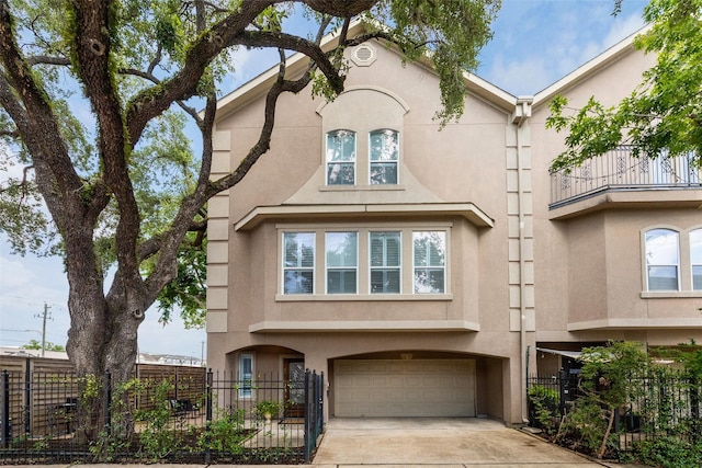 918 Detering St, Houston, TX 77007 - view of front of home with stucco siding, concrete driveway, an attached garage, and a fenced front yard