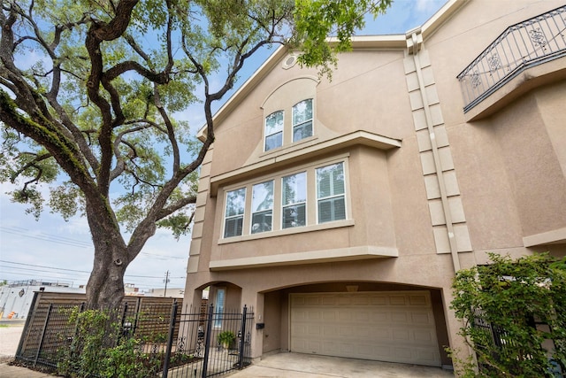 918 Detering St, Houston, TX 77007 - view of front of house with stucco siding, an attached garage, and concrete driveway