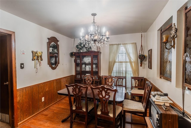 7726 Melanie St, Houston, TX 77016 - dining room with a chandelier, wainscoting, wooden walls, and wood finished floors
