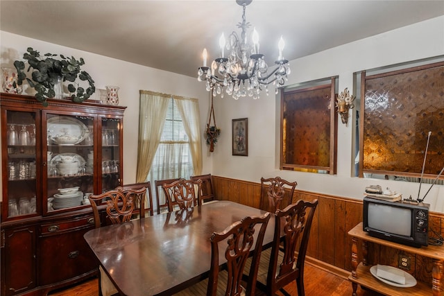 7726 Melanie St, Houston, TX 77016 - dining space featuring a wainscoted wall, a chandelier, wood finished floors, and wooden walls
