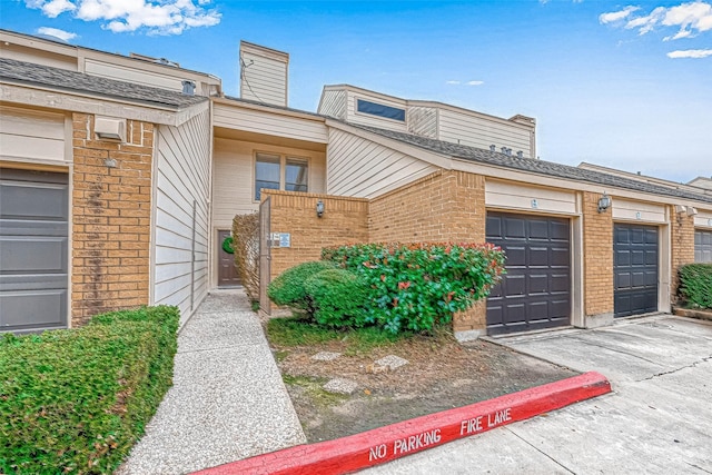 2277 S Kirkwood Rd Unit 906, Houston, TX 77077 - view of front of home with brick siding, community garages, and a chimney