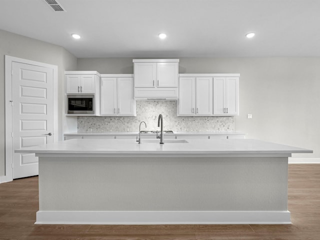 14328 Moonlit Creek Ct, Montgomery, TX 77316 - kitchen featuring stainless steel microwave, light countertops, tasteful backsplash, and recessed lighting