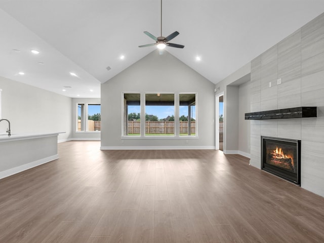 14328 Moonlit Creek Ct, Montgomery, TX 77316 - unfurnished living room with a tile fireplace, high vaulted ceiling, wood finished floors, ceiling fan, and recessed lighting