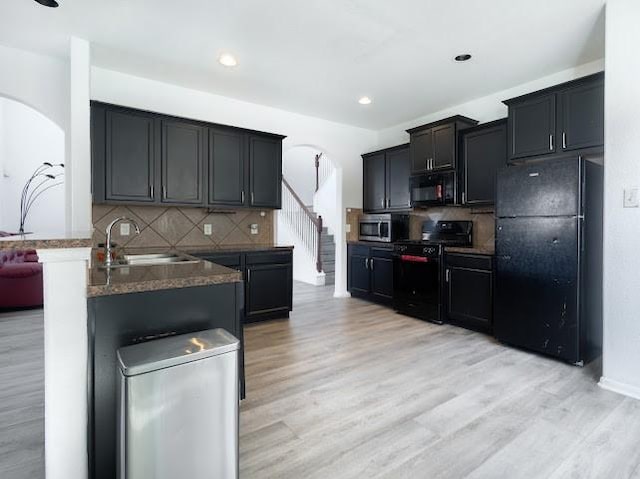 14110 Long Meadow Dr, Houston, TX 77047 - kitchen featuring black appliances, arched walkways, tasteful backsplash, light wood finished floors, and recessed lighting