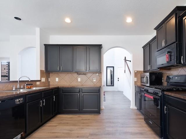 14110 Long Meadow Dr, Houston, TX 77047 - kitchen with black appliances, arched walkways, decorative backsplash, light wood-style flooring, and recessed lighting