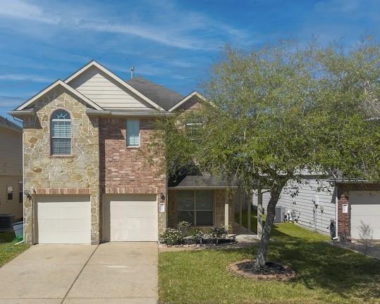 14110 Long Meadow Dr, Houston, TX 77047 - view of front of home with stone siding, driveway, a front lawn, an attached garage, and brick siding