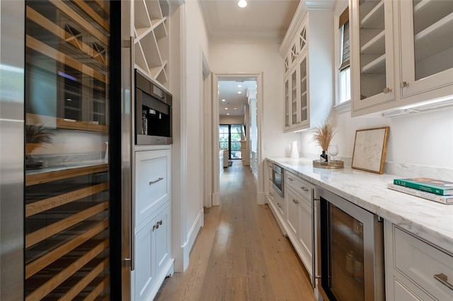 3028 Locke Ln, Houston, TX 77019 - bar featuring beverage cooler, stainless steel microwave, light wood-type flooring, and recessed lighting