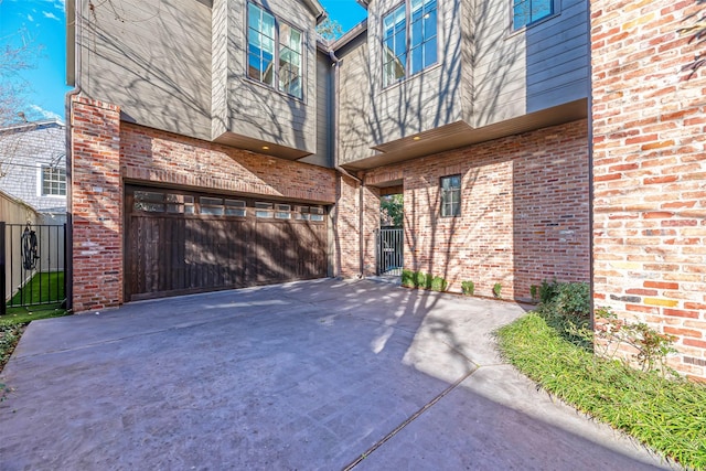 3028 Locke Ln, Houston, TX 77019 - view of side of home with an attached garage, driveway, and brick siding