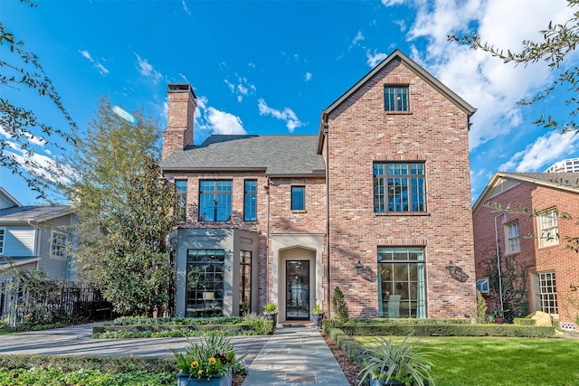 3028 Locke Ln, Houston, TX 77019 - view of front of house featuring a chimney, brick siding, roof with shingles, and a front yard
