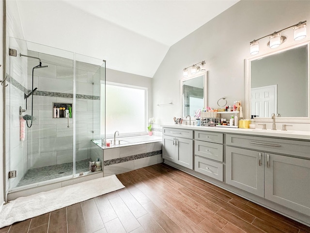 7902 Granite Ridge Ln, Houston, TX 77095 - full bathroom featuring double vanity, a garden tub, vaulted ceiling, a stall shower, and wood finished floors