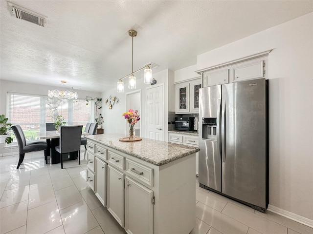 7902 Granite Ridge Ln, Houston, TX 77095 - kitchen featuring stainless steel refrigerator with ice dispenser, a textured ceiling, a chandelier, a center island, and pendant lighting