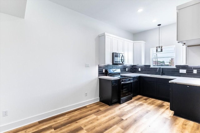 9804-9808 Pelsey St, Houston, TX 77029 - kitchen featuring black electric range, stainless steel microwave, backsplash, dark cabinetry, and light countertops