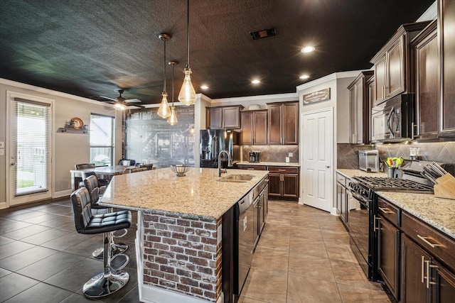 29513 Salem Fields Dr, Spring, TX 77386 - kitchen with black appliances, crown molding, a kitchen breakfast bar, tasteful backsplash, and an island with sink