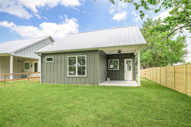 741 Pecan St, New Ulm, TX 78950 - rear view of house featuring a ceiling fan, board and batten siding, a fenced backyard, and a patio