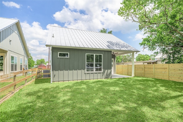 741 Pecan St, New Ulm, TX 78950 - back of house with board and batten siding, a fenced backyard, and a metal roof