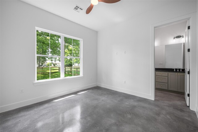 741 Pecan St, New Ulm, TX 78950 - unfurnished bedroom with finished concrete floors, ensuite bathroom, and a ceiling fan