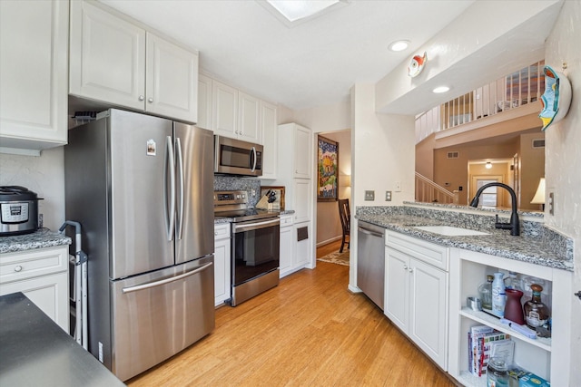 9400 Doliver Dr Unit 30, Houston, TX 77063 - kitchen with stainless steel appliances, light wood-style flooring, and white cabinets