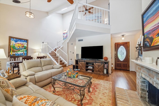 9400 Doliver Dr Unit 30, Houston, TX 77063 - living area featuring ceiling fan, hardwood / wood-style floors, stairway, a towering ceiling, and a brick fireplace