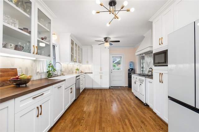 6625 Fairfield St, Houston, TX 77023 - kitchen with white appliances, custom exhaust hood, butcher block countertops, white cabinetry, and a chandelier