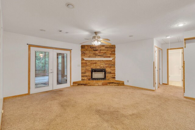 123 Sea Gull Dr, Livingston, TX 77351 - unfurnished living room with french doors, attic access, carpet floors, ceiling fan, and a stone fireplace