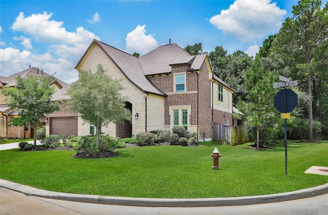 145 Bronze Bow Dr, Montgomery, TX 77316 - view of front of property with stone siding, an attached garage, a front yard, brick siding, and a shingled roof