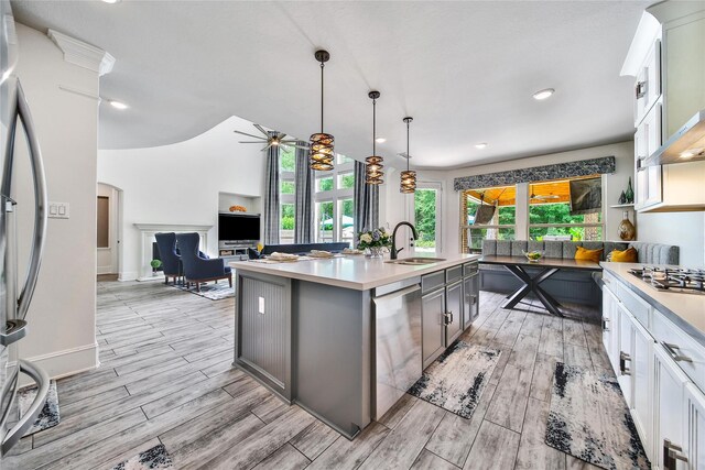 145 Bronze Bow Dr, Montgomery, TX 77316 - kitchen featuring stainless steel appliances, arched walkways, light countertops, a ceiling fan, and light wood-type flooring
