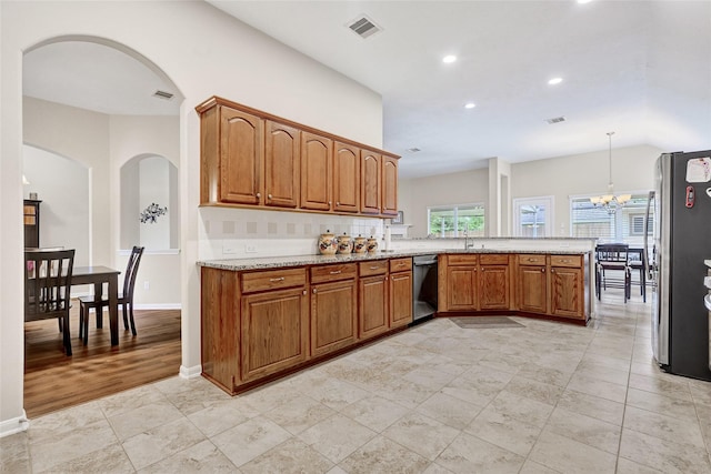 6318 Crystal Forest Trl, Katy, TX 77493 - kitchen featuring arched walkways, stainless steel appliances, brown cabinetry, light stone countertops, and recessed lighting