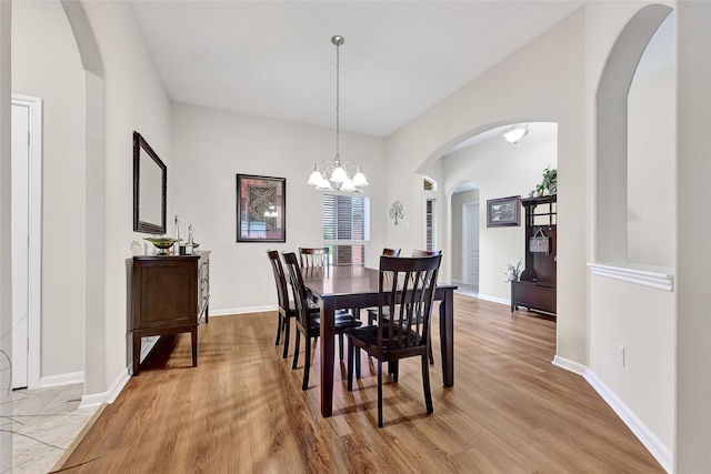 6318 Crystal Forest Trl, Katy, TX 77493 - dining space with light wood-type flooring, a chandelier, and arched walkways