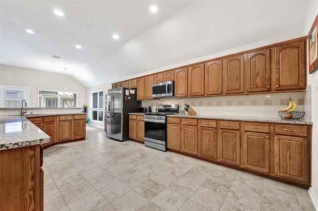 6318 Crystal Forest Trl, Katy, TX 77493 - kitchen featuring appliances with stainless steel finishes, vaulted ceiling, tasteful backsplash, brown cabinetry, and recessed lighting