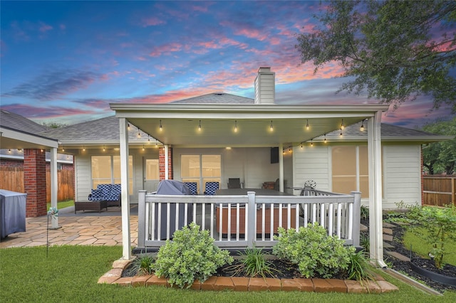 6318 Crystal Forest Trl, Katy, TX 77493 - back of property at dusk with a patio area, a chimney, and roof with shingles