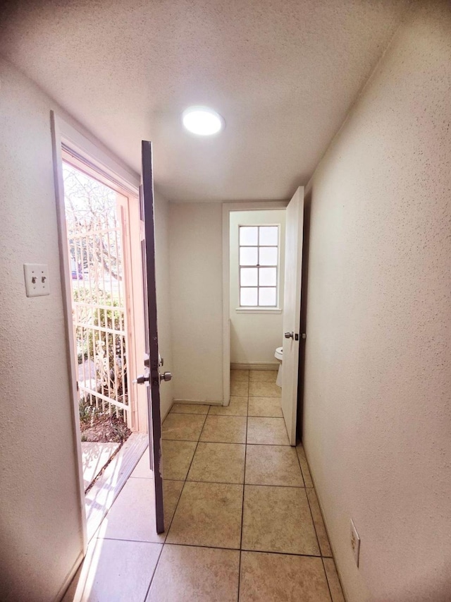 7837 Leonora St, Houston, TX 77061 - hall featuring light tile patterned flooring, a textured wall, and a textured ceiling