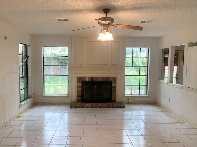 3027 Country Club Blvd, Sugar Land, TX 77478 - unfurnished living room with a ceiling fan, light tile patterned floors, a textured ceiling, and a brick fireplace