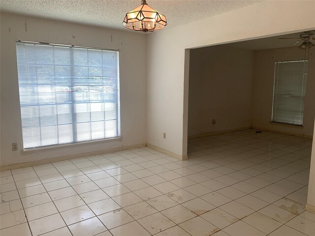 3027 Country Club Blvd, Sugar Land, TX 77478 - unfurnished room featuring a textured ceiling, a chandelier, light tile patterned flooring, and ceiling fan