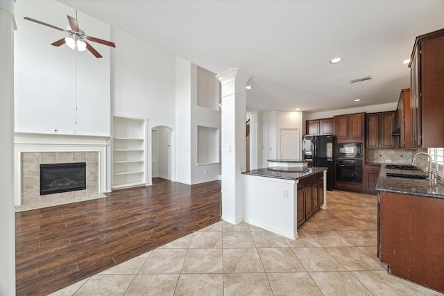 26314 Planters Heath, Katy, TX 77494 - kitchen featuring black appliances, ceiling fan, dark stone counters, decorative columns, and tasteful backsplash