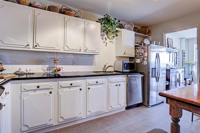 2200 Willowick Rd Unit 7B, Houston, TX 77027 - kitchen with appliances with stainless steel finishes, dark countertops, white cabinets, and tasteful backsplash