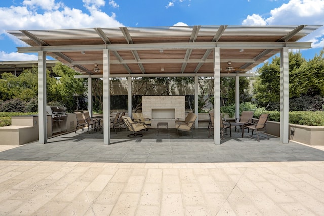 2200 Willowick Rd Unit 7B, Houston, TX 77027 - view of patio with exterior fireplace, ceiling fan, and exterior kitchen
