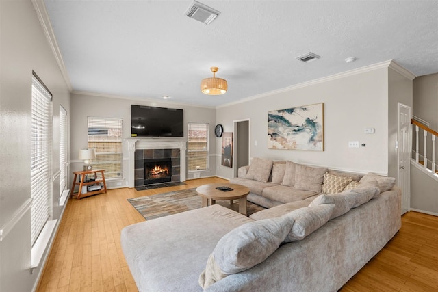 21519 San Marino Dr, Katy, TX 77450 - living area featuring ornamental molding, light wood-style floors, a fireplace, and stairs