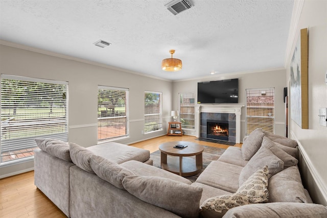 21519 San Marino Dr, Katy, TX 77450 - living room with crown molding, light wood-style floors, a textured ceiling, and a tile fireplace
