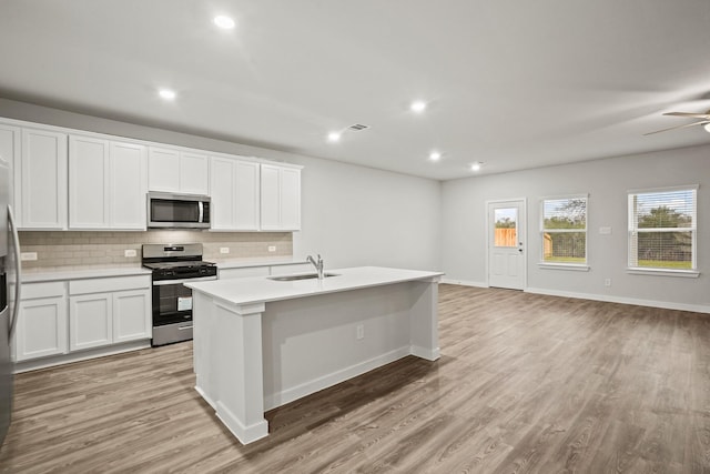 25011 Pomegranate Pl, Montgomery, TX 77316 - kitchen with appliances with stainless steel finishes, tasteful backsplash, open floor plan, an island with sink, and recessed lighting