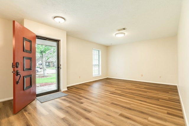 2910 Castle Ct, Pearland, TX 77581 - entrance foyer with healthy amount of natural light, light wood-style floors, and a textured ceiling
